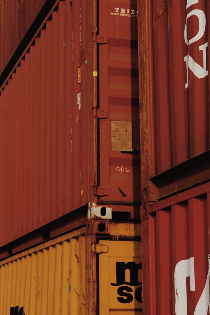 brand-02 Close-up view of stacked rusty cargo containers highlighting industrial textures.