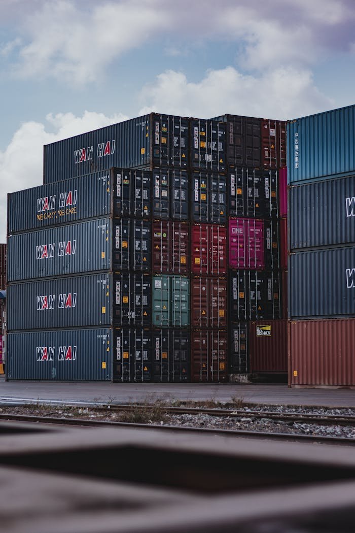 brand-03 High vertical stack of cargo containers at a port, symbolizing global logistics.